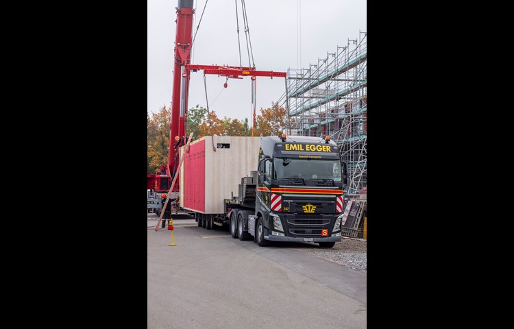 Ein Kran hob die Zimmer vom Schwertransporter in luftige Höhen.