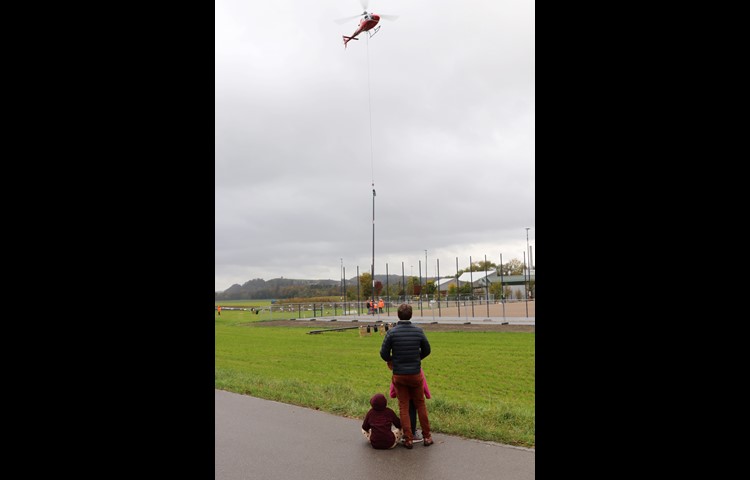 Zaungäste verfolgten die Arbeiten mit dem Heli. Die Masten für den Ballfänger wurden von Hand aufgestellt.