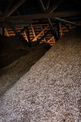 Um das in der Sägerei anfallende Restholz vollständig vor Ort zu verwerten, betreibt die Konrad Keller AG seit 1990 einen Wärmeverbund mit Holzschnitzelheizung (hier das Schnitzellager). Die Anlage wurde seither vergrös­sert und modernisiert und bietet genug Reserve zur Verbundserweiterung.