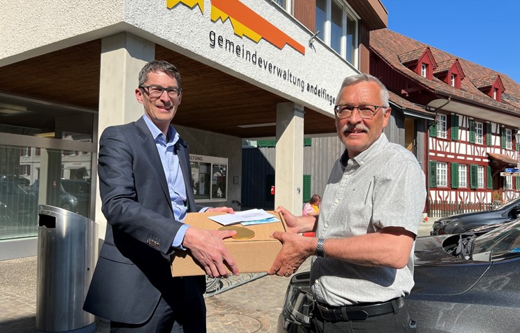 Thomas Müller von der ZKB Andelfingen überreicht Gemeindepräsident Hansruedi Jucker (rechts) das Geld in Papierform, als harte Währung in Form von Schoggitalern sowie einen Apéro für die Verwaltung. Thomas Müller von der ZKB Andelfingen überreicht Gemeindepräsident Hansruedi Jucker (rechts) das Geld in Papierform, als harte Währung in Form von Schoggitalern sowie einen Apéro für die Verwaltung.
