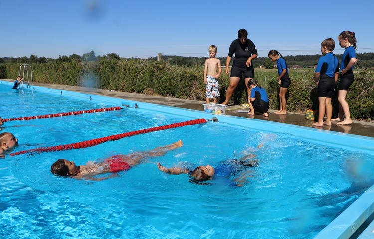 Rückenkraulen: Etwas, das die Kinder im Laufe der Intensivschwimmkurs-Woche von Schwimmlehrerin Yvonne Schmid (im schwarzen Neopren) gelernt haben. Rückenkraulen: Etwas, das die Kinder im Laufe der Intensivschwimmkurs-Woche von Schwimmlehrerin Yvonne Schmid (im schwarzen Neopren) gelernt haben.