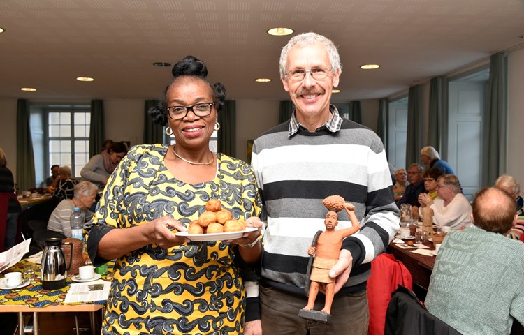 Jeannette Malonda Egg-Kuelo mit den frittierten Bällchen und Urs Weilenmann mit der geschnitzten Figur eines Palmöl-Ernters. Mit dem Band sichert er sich am Baum, die Frucht trägt er auf dem Kopf. Jeannette Malonda Egg-Kuelo mit den frittierten Bällchen und Urs Weilenmann mit der geschnitzten Figur eines Palmöl-Ernters. Mit dem Band sichert er sich am Baum, die Frucht trägt er auf dem Kopf.