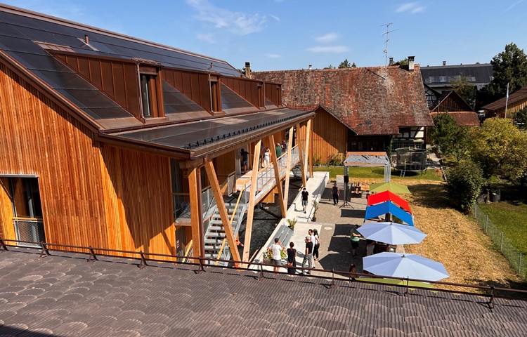 Blick aus der westlichen Dachwohnung des Haupthauses des einem «bäuerlichen Vielzweckbau» nachgeahmten Ensembles. Auf dem Dach sorgt eine Solaranlage mit 58 Kilowatt Leistung für genug Strom, hinten neben der Pergola ist der Lichtschacht, der wegen dem möglichen Hochwasser aus dem Boden ragt. Blick aus der westlichen Dachwohnung des Haupthauses des einem «bäuerlichen Vielzweckbau» nachgeahmten Ensembles. Auf dem Dach sorgt eine Solaranlage mit 58 Kilowatt Leistung für genug Strom, hinten neben der Pergola ist der Lichtschacht, der wegen dem möglichen Hochwasser aus dem Boden ragt.