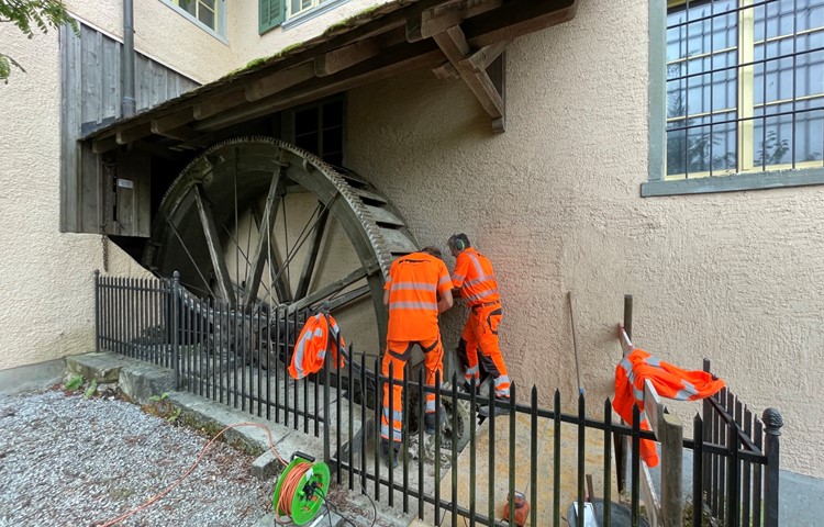 Kalkablagerungen unerwünscht: Der Zahnkranz auf der Vorderseite des Mühlrads muss sauber ins kleinere Ritzel (zu Füssen der Arbeiter) greifen können. Kalkablagerungen unerwünscht: Der Zahnkranz auf der Vorderseite des Mühlrads muss sauber ins kleinere Ritzel (zu Füssen der Arbeiter) greifen können.