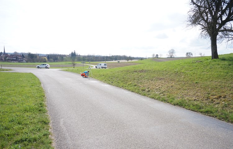 Ein Mitarbeiter des Ingenieurbüros Steinmann markierte am Mittwoch den Radweg: Auf der rechten Seite kommt dieser erhöht 2,5 Meter auf die Radstrasse zu liegen, auf der linken wird die Strasse 3,5 Meter verbreitert. Im Hintergrund links die Kirche Marthalen, rechts das Guggebüelhüsli. Nach der Kuppe führt der Feldweg zur Chinze mit einem Gefälle von 12,5 Prozent, die Kreuzung zwischen den Autos (Bild) wird ausgebaut. Ein Mitarbeiter des Ingenieurbüros Steinmann markierte am Mittwoch den Radweg: Auf der rechten Seite kommt dieser erhöht 2,5 Meter auf die Radstrasse zu liegen, auf der linken wird die Strasse 3,5 Meter verbreitert. Im Hintergrund links die Kirche Marthalen, rechts das Guggebüelhüsli. Nach der Kuppe führt der Feldweg zur Chinze mit einem Gefälle von 12,5 Prozent, die Kreuzung zwischen den Autos (Bild) wird ausgebaut.